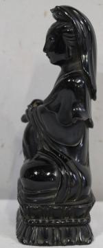 Sujet en bois laquée noir représentant la déesse Guanyin assise...