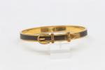 HERMES: Bracelet rigide de forme ceinture  en métal doré...