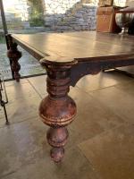 Grande table en bois patiné brun-rouge reposants sur quatre pieds...