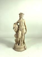 Statuette en terre cuite figurant une femme à l'antique tenant...