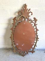 Miroir ovale en bois stuqué doré à décor de rinceaux,...