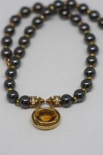 Collier de perles grises alternées d'or et au centre pendentif...
