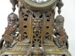 Pendule en bronze patiné marron à décor de lions, mascaron...