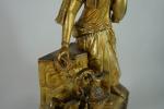 Pendule en bronze doré à l'effigie d'une orientale assise, tenant...