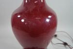 Lampe balustre en porcelaine imitant la laque rouge, sans abat-jour...