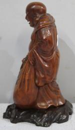 Bouddha en bois sur son socle . hauteur 21 cm...