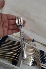ERCUIS : Ménagère en métal argenté à décor de coquille...