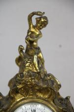 Pendule en bronze doré à décors d'angelots , de style...