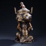 BRULE-PARFUM couvert en bronze soutenu par un personnage assis. Extrême-Orient...