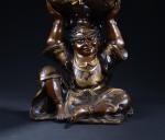 BRULE-PARFUM couvert en bronze soutenu par un personnage assis. Extrême-Orient...