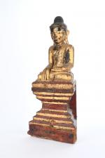 STATUETTE de Bouddha assis en tailleur sur un socle, prenant...