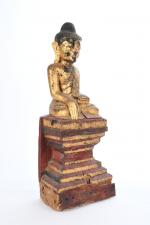 STATUETTE de Bouddha assis en tailleur sur un socle, prenant...