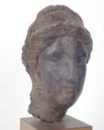 TÊTE FEMININE romaine en terre cuite noire, le visage resculpté....
