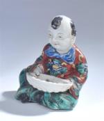 MAGOT assis tenant une coupe en porcelaine polychrome, Extrême-Orient époque...