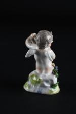 SAXE XIXème, angelot tenant un cartouche fleuri, sur tertre. Porcelaine....