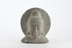 ASIE (moderne). "Divinité", tête en pierre sculptée auréolée. H. 30...
