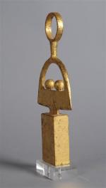 STATUETTE en métal doré représentant une femme stylisée, travail moderniste....