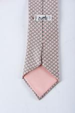 HERMES Paris - Cravate en soie, motif dauphins fond rose,...