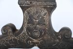 CHENETS (paire de) en bronze, décor de visages grimaçants surmontés...
