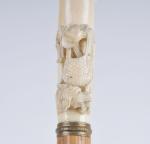 CANNE pommeau ivoire décor de chasse. L.88 cm.