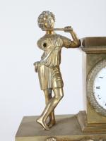 * PENDULETTE (petite) en bronze à décor d'un flutiste. Epoque...