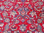 IRAN. TAPIS de laine à fond rouge et rosace centrale....