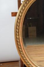 MIROIR ovale en bois et composition dorée surmonté d'un ruban...