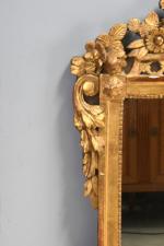 MIROIR en bois sculpté et doré, le fronton à décor...