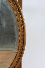 MIROIR ovale en bois et composition dorée à fronton ajouré...
