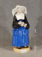 Tisanière en porcelaine polychrome figurant une religieuse tenant dans sa...