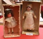Deux petites poupées en boîte,
tête porcelaine : l'une bouche ouverte...
