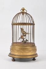 Cage ronde à un oiseau chanteur
en métal doré, mouvement de...