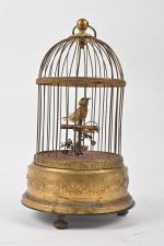 Cage ronde à un oiseau chanteur
en métal doré, mouvement de...