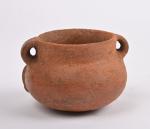Vase anthropomorphe à deux anses en céramique orangée
lustrée représentant un...