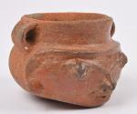 Vase anthropomorphe à deux anses en céramique orangée
lustrée représentant un...