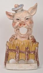 Passe-boule en plâtre armé et peint 
représentant un petit cochon,...