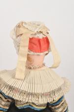 Poupée tête en composition 
habillée en bretonne sous globe.