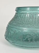 Art islamique
Vase en verre bleu a décor d'inscriptions arabes gravées....