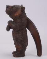 Casse-noix en bois sculpté 
partiellement polychrome figurant un ourse dressé,...