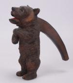 Casse-noix en bois sculpté 
partiellement polychrome figurant un ourse dressé,...