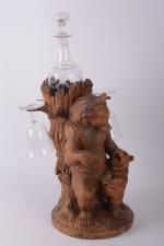 Cave à liqueur en bois 
sculpté figurant une oursonne nourrissant...