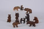 Douze petits ours en bois sculpté assis ou dressés. 
Travail...