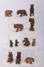 Douze petits ours en bois sculpté assis ou dressés. 
Travail...