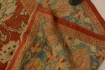 Russie
Grand tapis à fond corail, à motifs floraux ronds bleus...