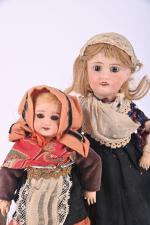 Deux poupées tête porcelaine
en habits traditionnels, corps tout articulé, une...
