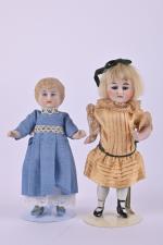 Deux petites poupées tout en biscuit,
tête fixe, chaussures peintes, habits...