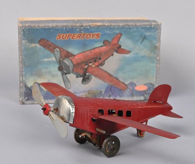 France, avion mécanique en tôle peinte rouge, ailes repliables, l. 18 cm (usures). - auctions