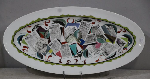 Plat à poisson en porcelaine polychrome à décor de coupures de journaux russes en son centre et daté  1921 . L: 60 cm. Blason Nicolas II au dos et datée 1910