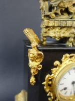 Pendule d'époque Louis-Philippe en marbre noir et bronze doré, surmontée...