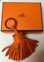 HERMES PARIS - PORTE-CLEFS "Pompon" en cuir orange. Dans sa...